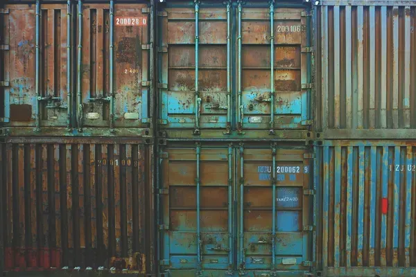 A row of rusty shipping containers stacked on top of each other.