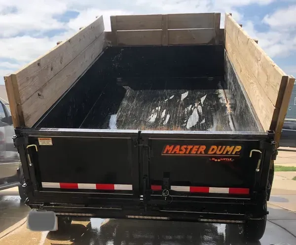 A black dump truck with the word master dump on it
