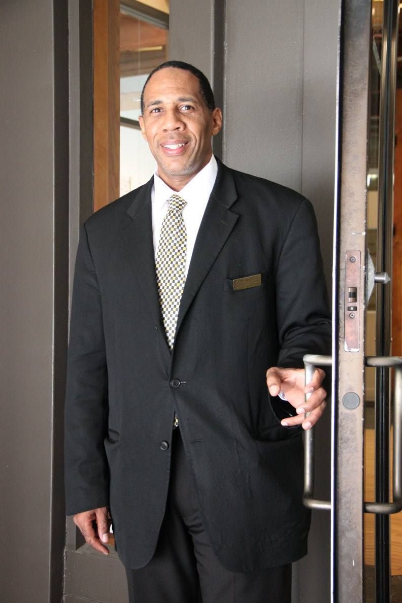A man in a suit and tie is standing in front of stairs