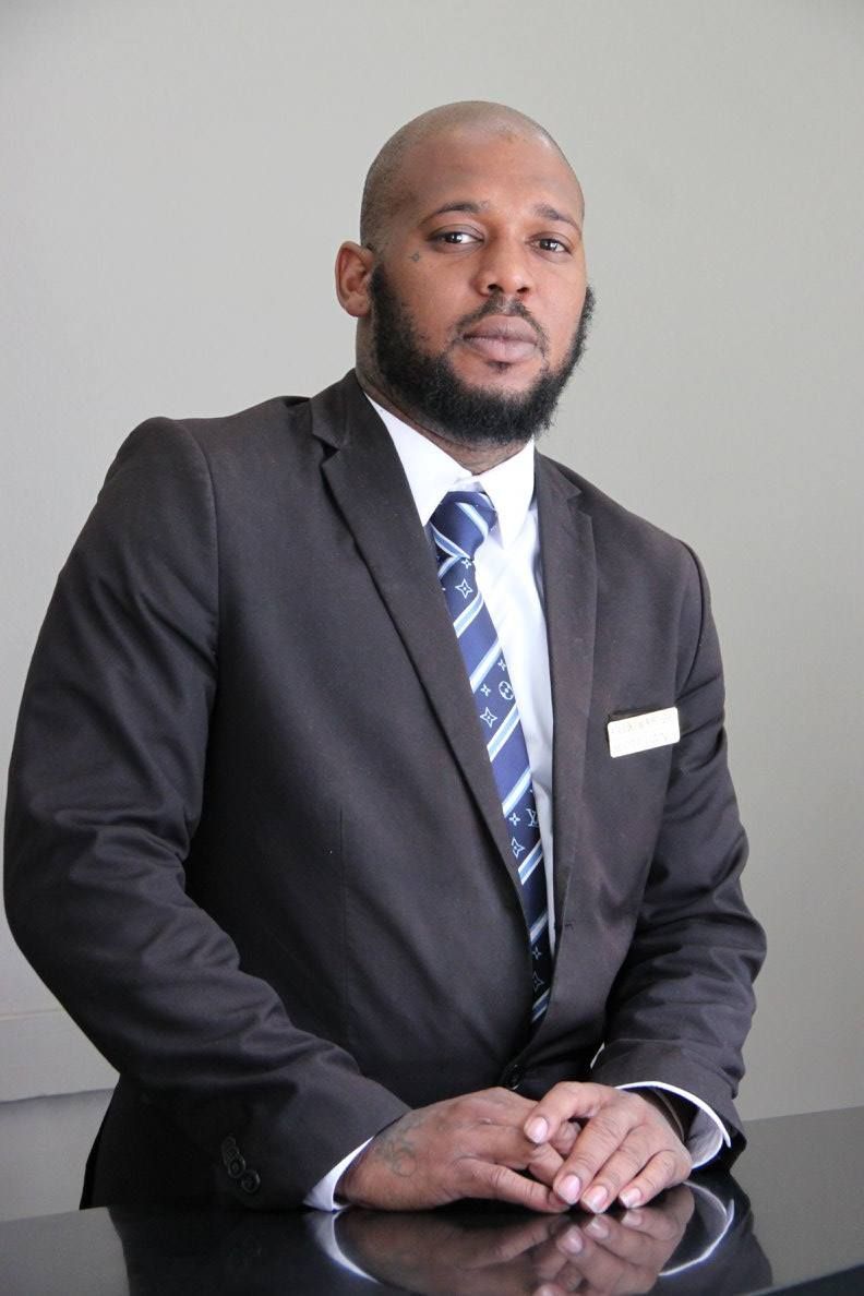 A man in a suit and tie is sitting at a desk