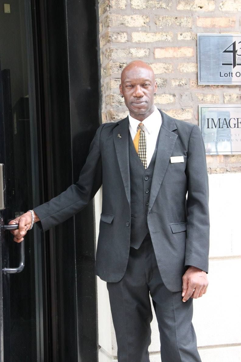 A man in a suit and tie is standing in front of a door