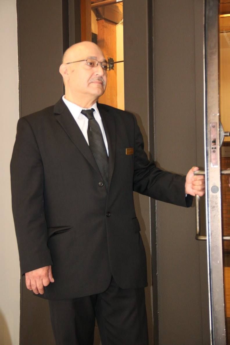 A man in a suit and tie is opening a door