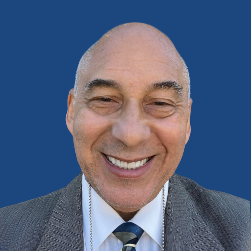 A man in a suit and tie is smiling for the camera