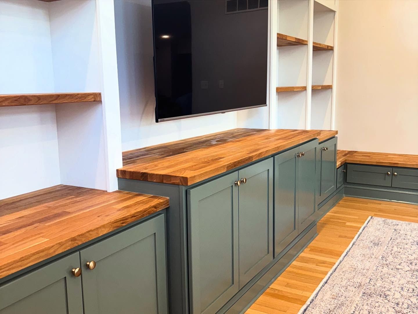 Woman in straw hat smiles, holding wine glass near a lake.
