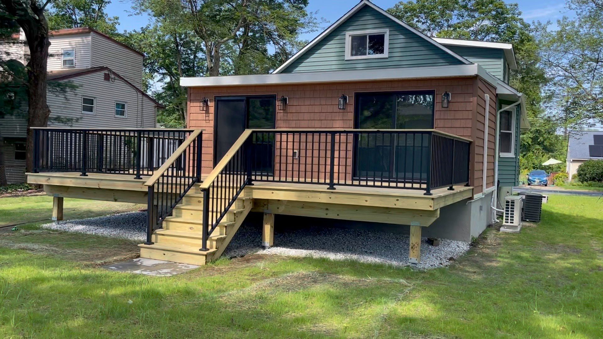 Woman in straw hat smiles, holding wine glass near a lake.