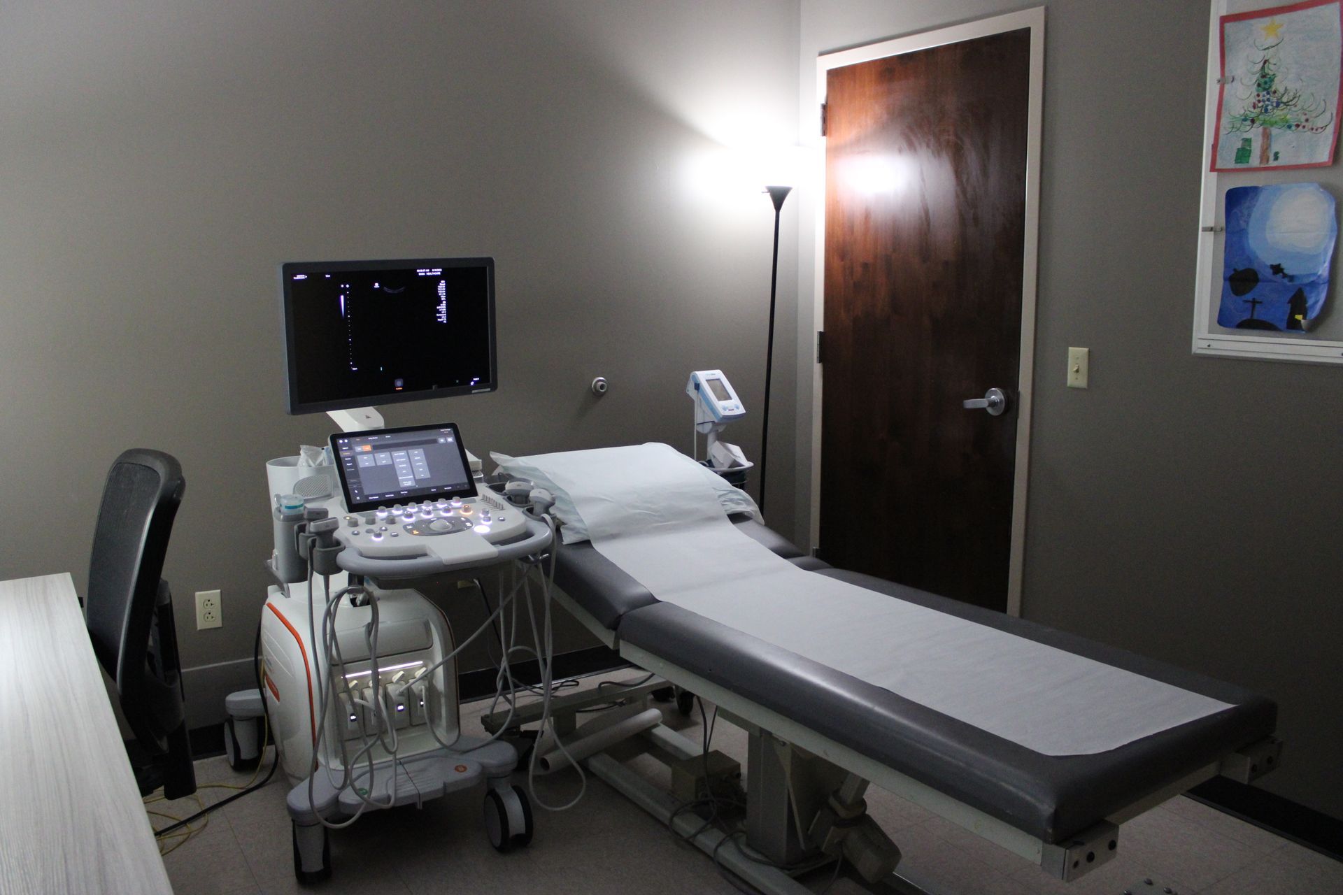An ultrasound room with medical equipment and examination table.