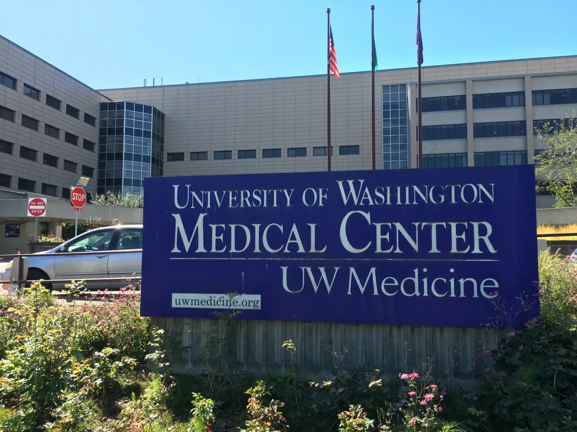 University of Washington Medical Center sign with hospital buildings behind it