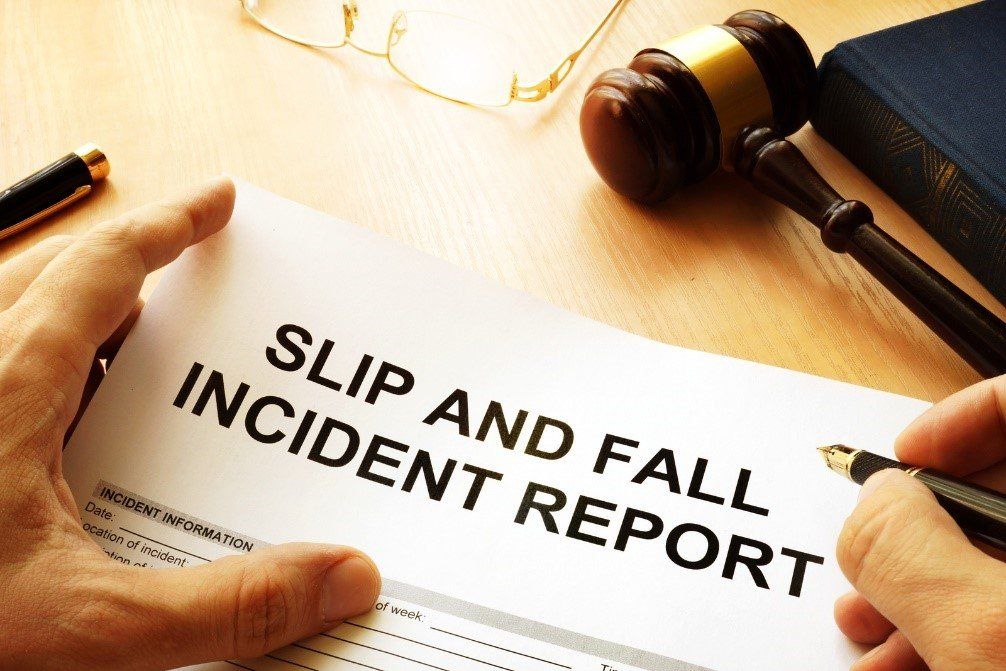 A person filling out a slip and fall incident report.