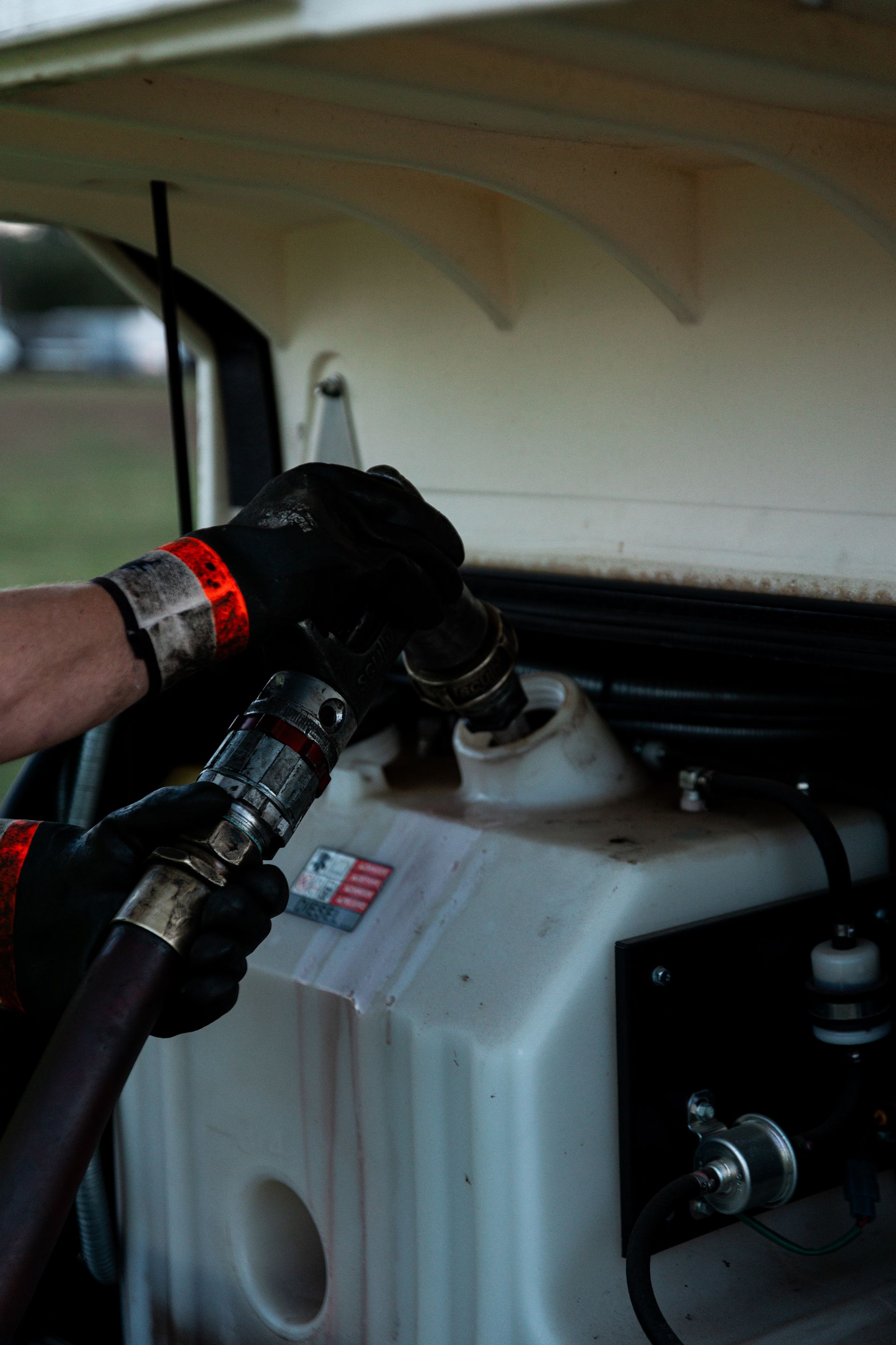 A person is pumping diesel into a tank with a hose.