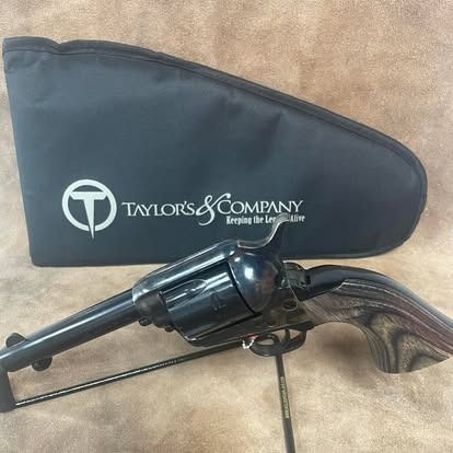 Black revolver pistol with a Taylor's & Company case on a brown surface.