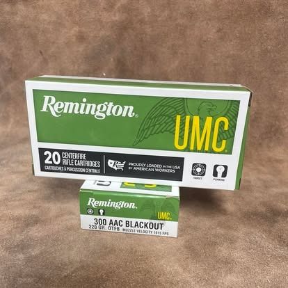 Two boxes of Remington UMC ammunition, one larger and green, the smaller one labeled 