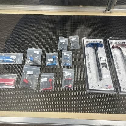 Firearm parts displayed in retail packaging on a counter.
