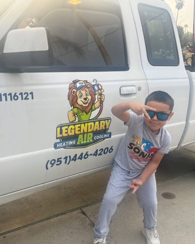 A young boy standing in front of a legendary air truck