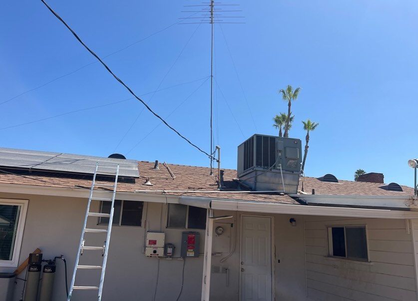 A ladder is sitting on the roof of a house