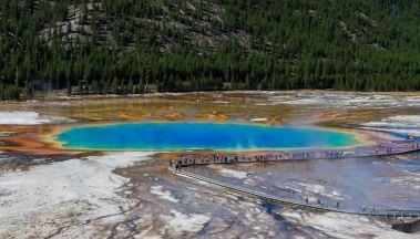 View of the radiant turquoise Grand Prismatic Spring with brilliant orange bacterial mat surrounding