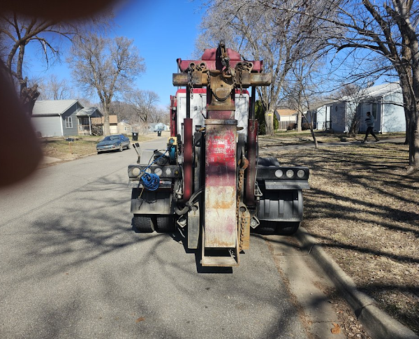 A tow truck is parked on the side of the road