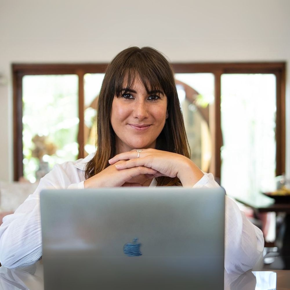 A woman is sitting in front of an apple laptop