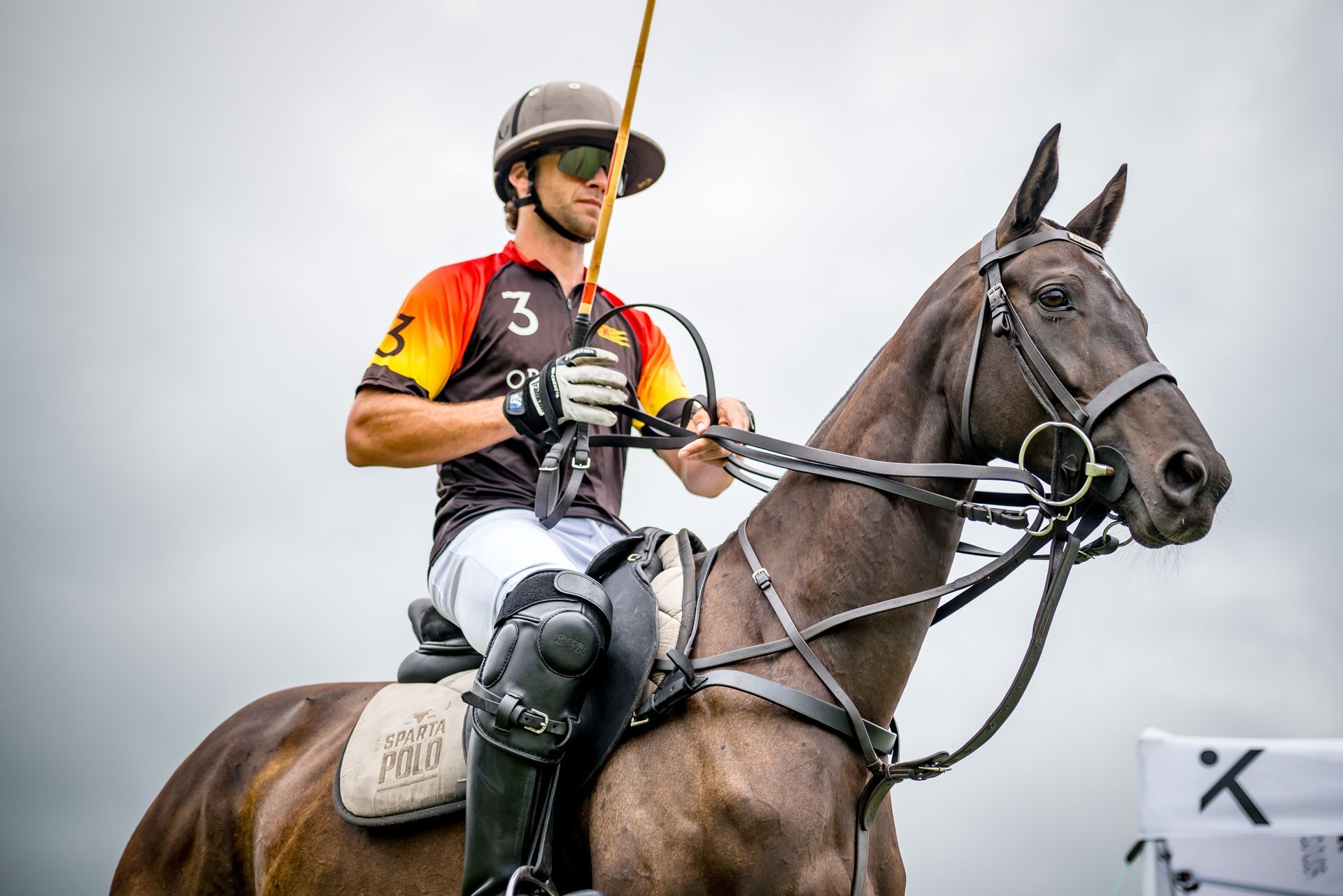 A man is riding a horse with a stick in his hand.