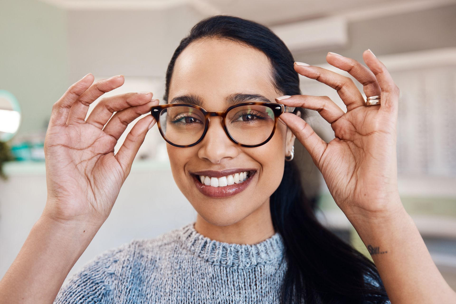 young woman buying new pair of glasses