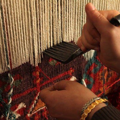 Woman hand-weaving a colorful rug — Rug Cleaner and Repairs in Memphis, TN