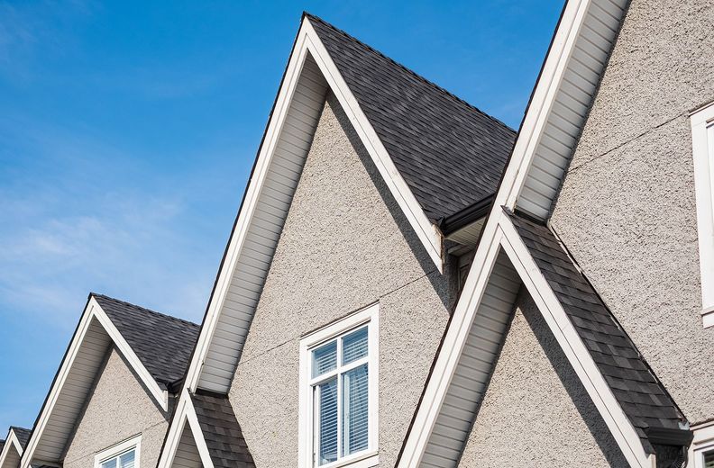 A row of houses with a blue sky in the background.