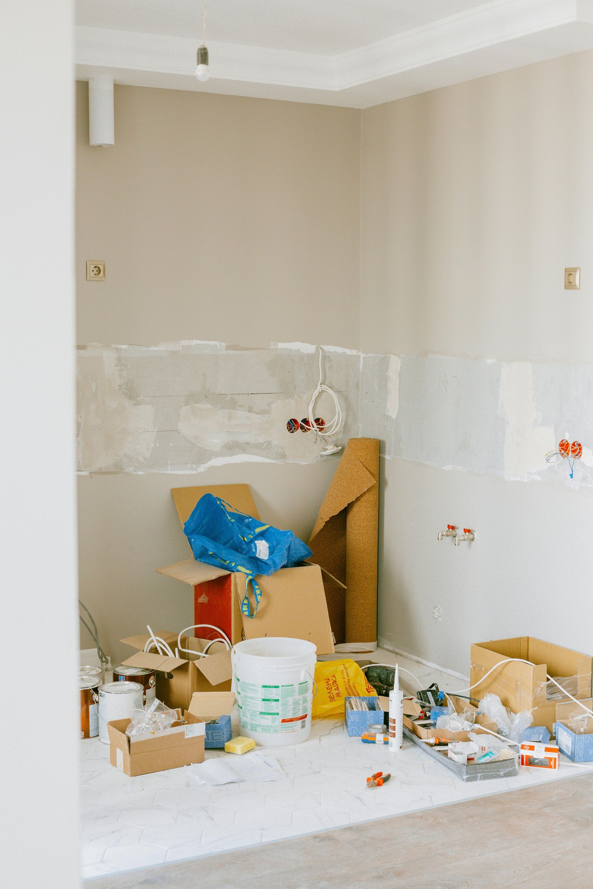 A room with a lot of boxes and tools on the floor.