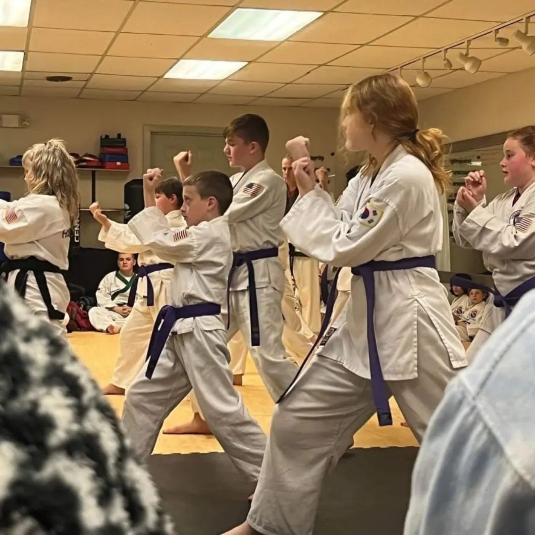 Two men grappling on a mat, one in blue, the other in black.