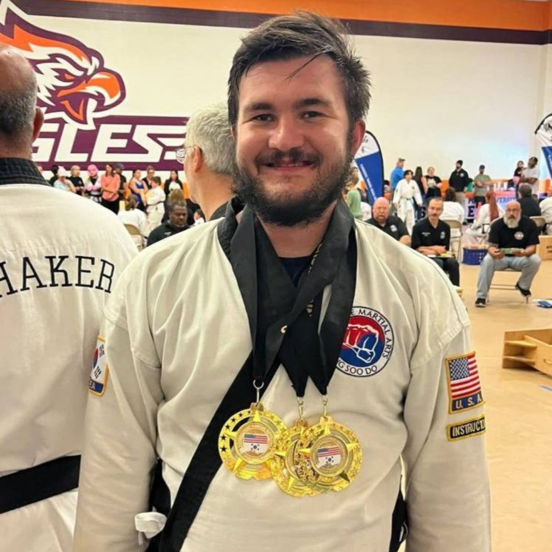 Two people practicing Brazilian Jiu-Jitsu on a mat; one in a black gi, one in a white gi, grappling.