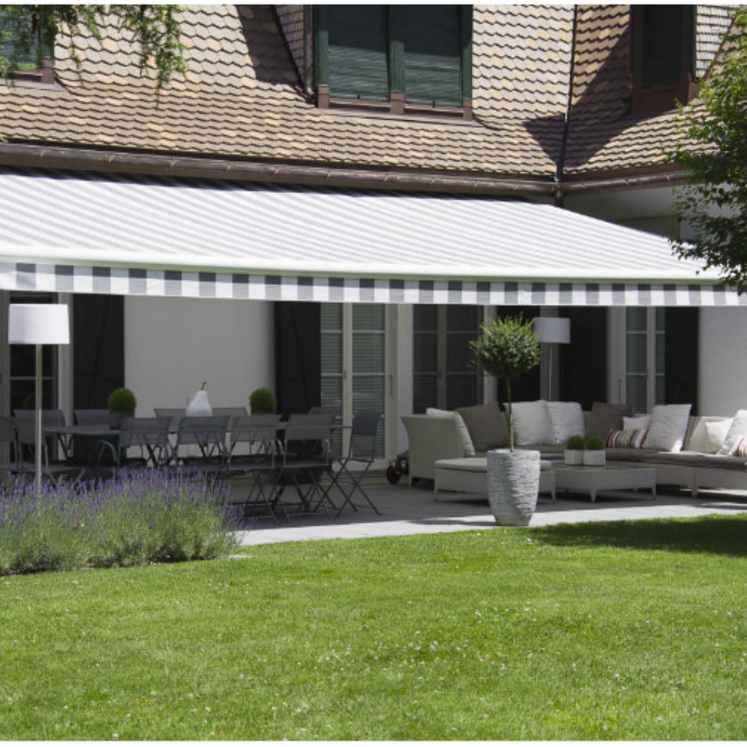 Une maison avec un auvent blanc sur un patio meublé