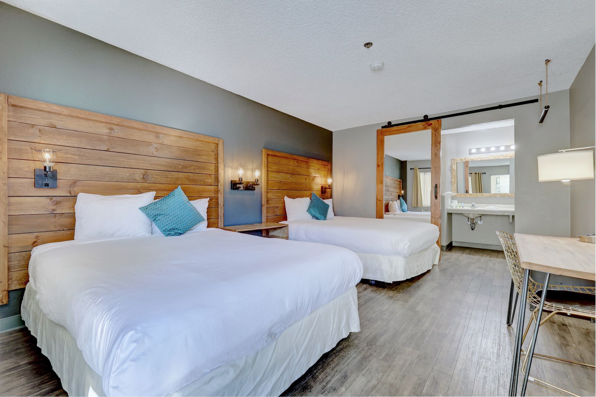 A hotel room with two beds and a table.