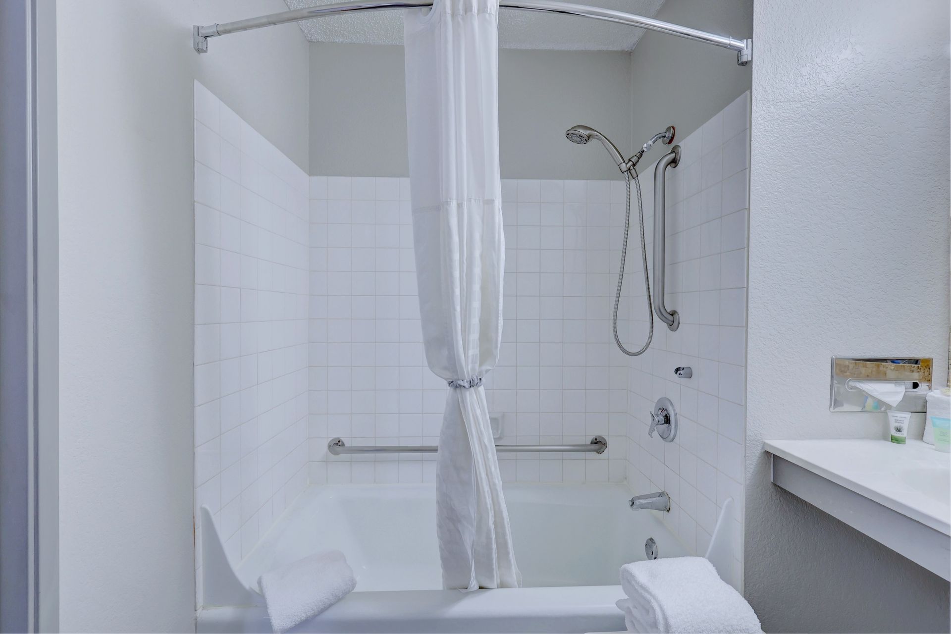 A bathroom with a bathtub , shower , and sink.