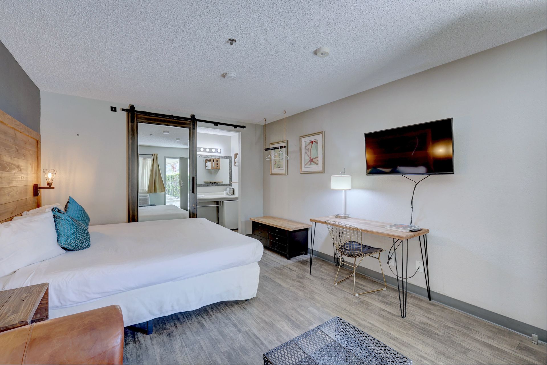 A hotel room with a king size bed , desk , chair and television.
