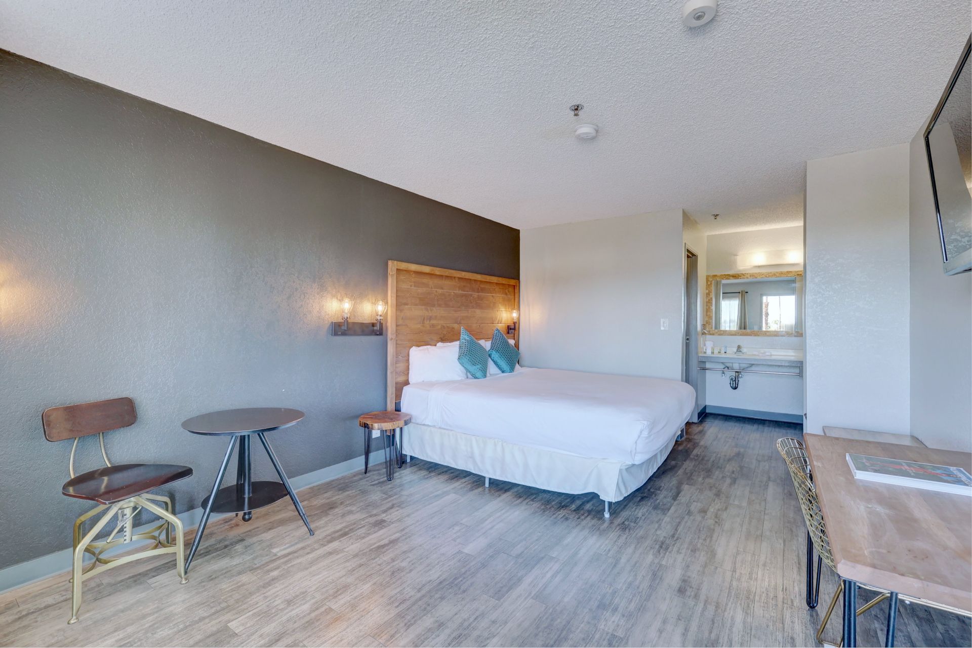 A hotel room with a king size bed , table and chairs.