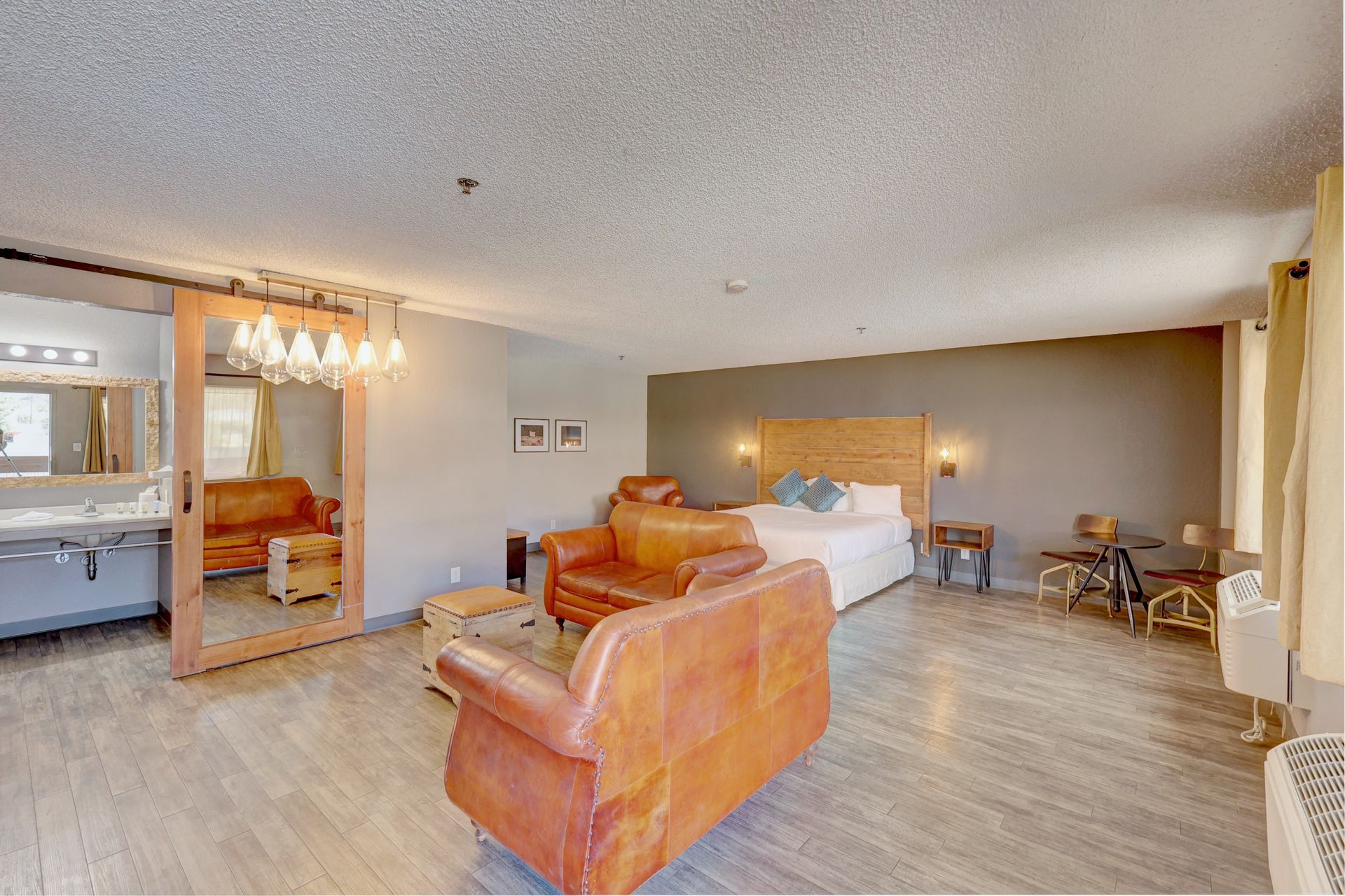 A hotel room with a couch , chair , and bed.
