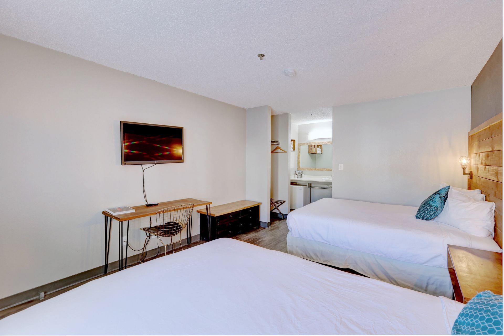 A hotel room with two beds and a flat screen tv.