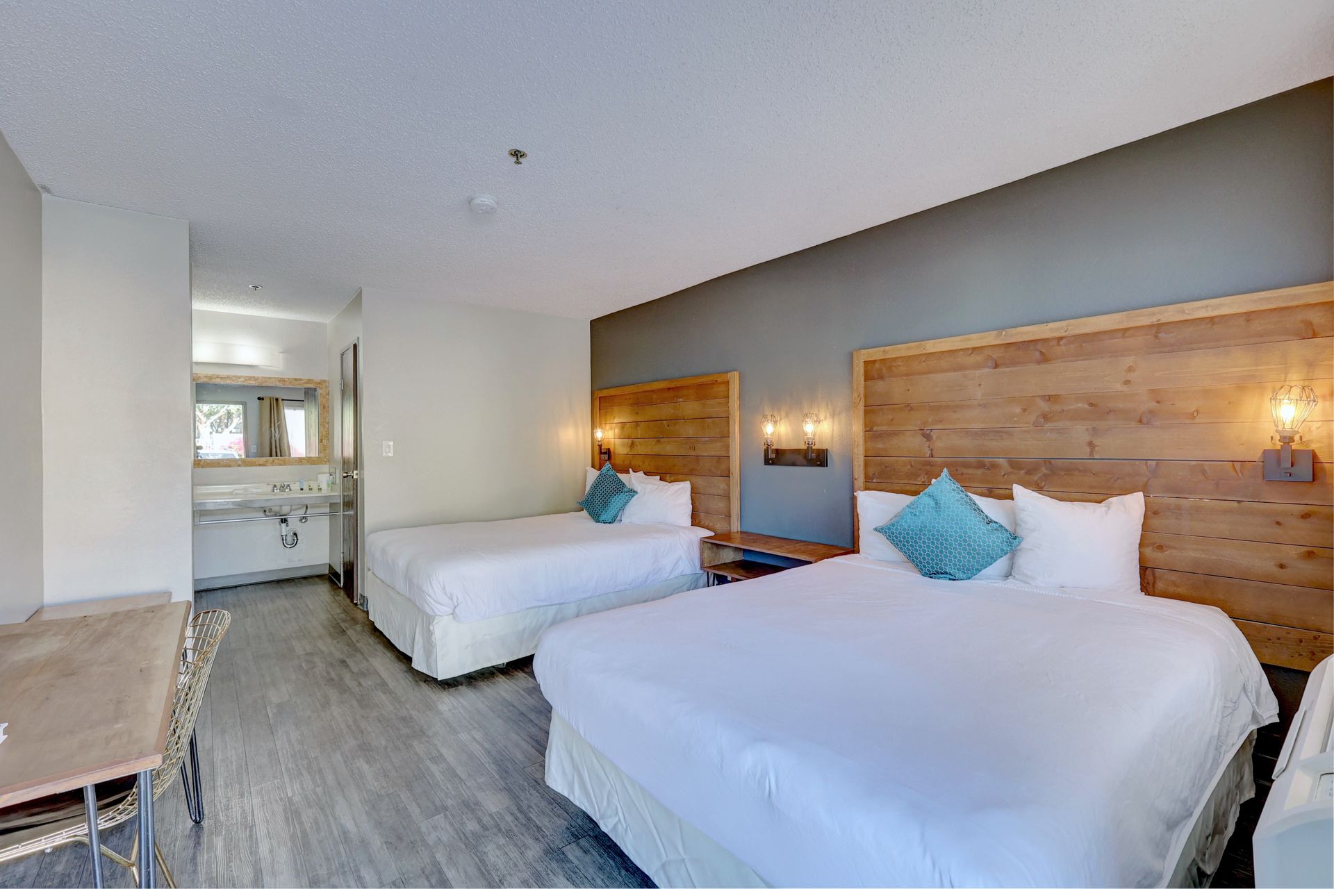 A hotel room with two beds , a table and chairs.