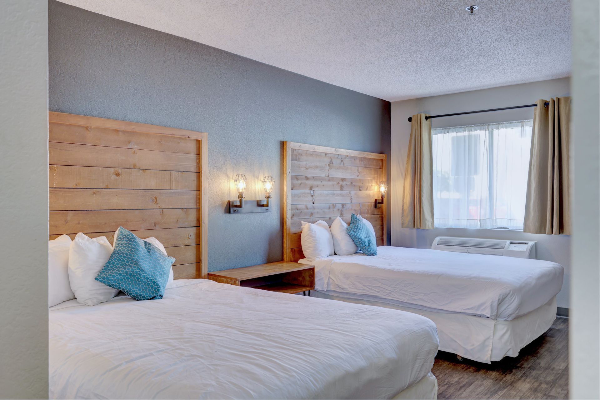 A hotel room with two beds and a window