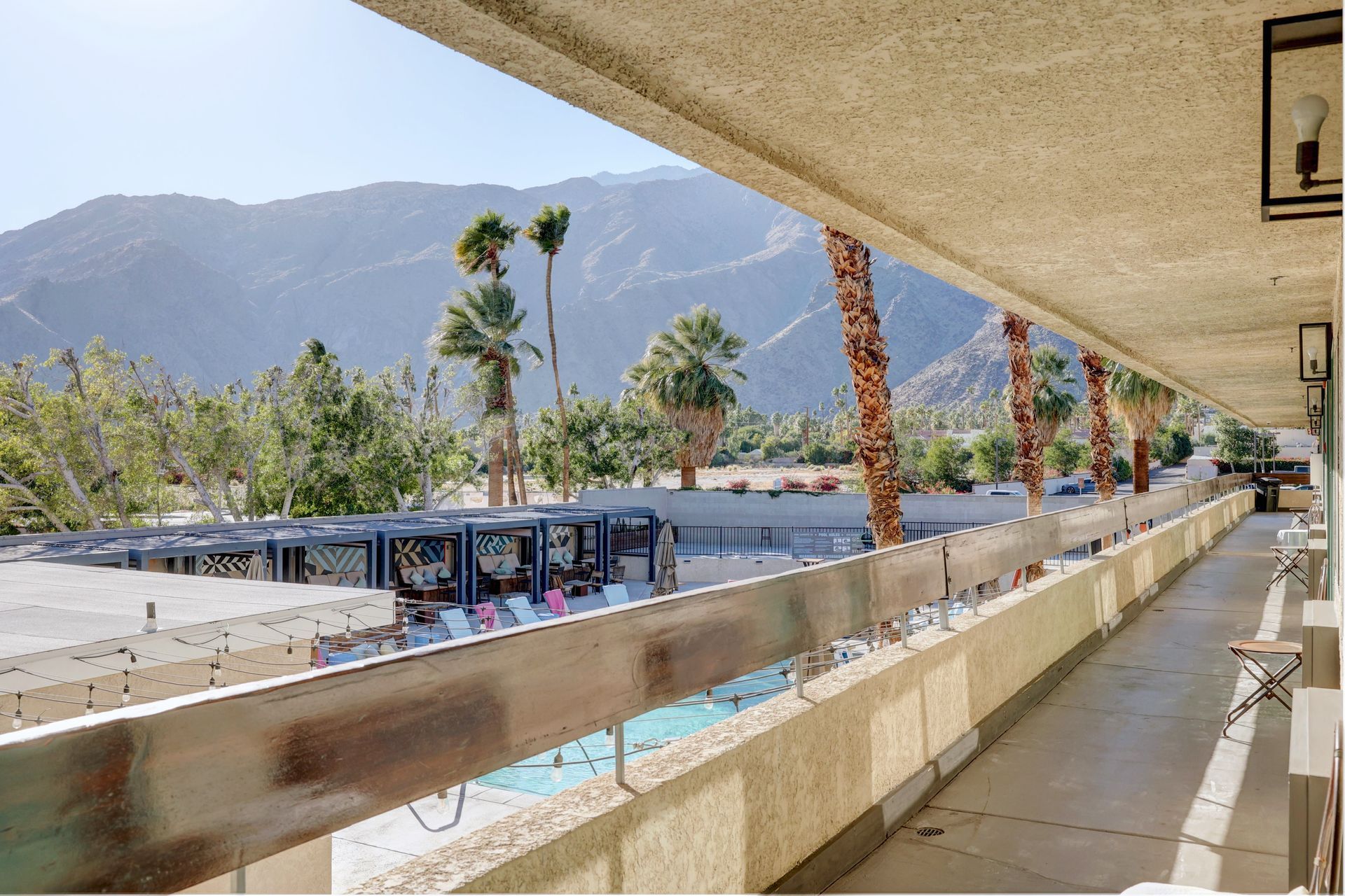 A balcony with a view of mountains and palm trees