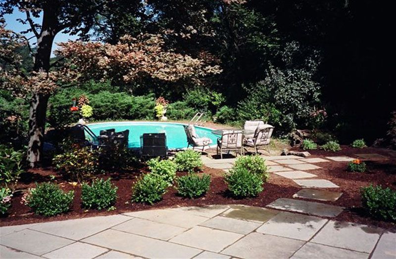 A patio with a swimming pool in the background