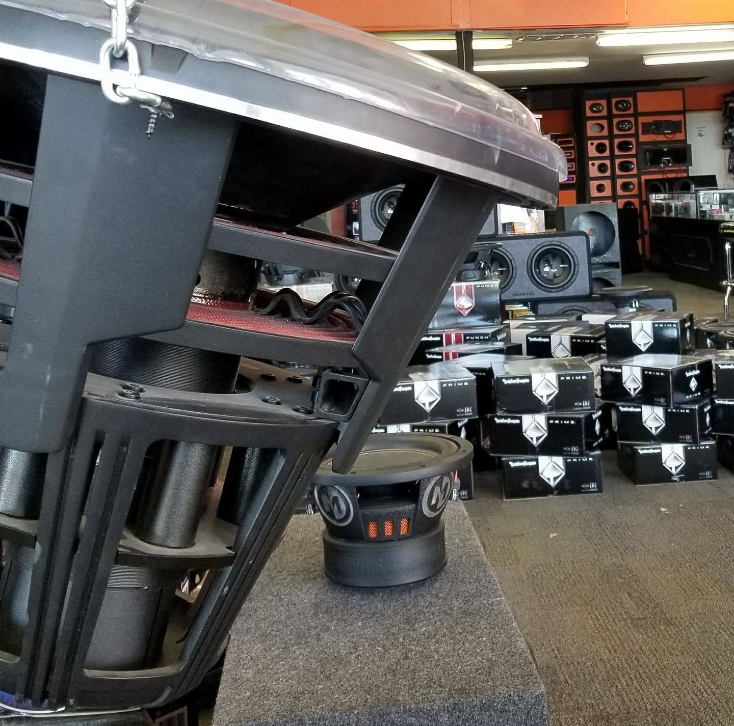 Car audio store interior with multiple subwoofers on display.