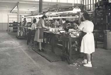 A black and white photo of people working in a factory.