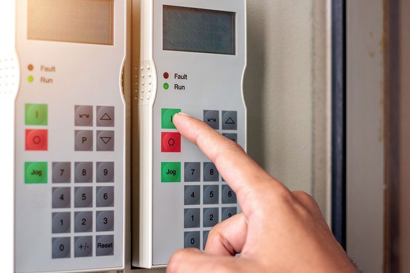 A person is pressing a button on a security system.