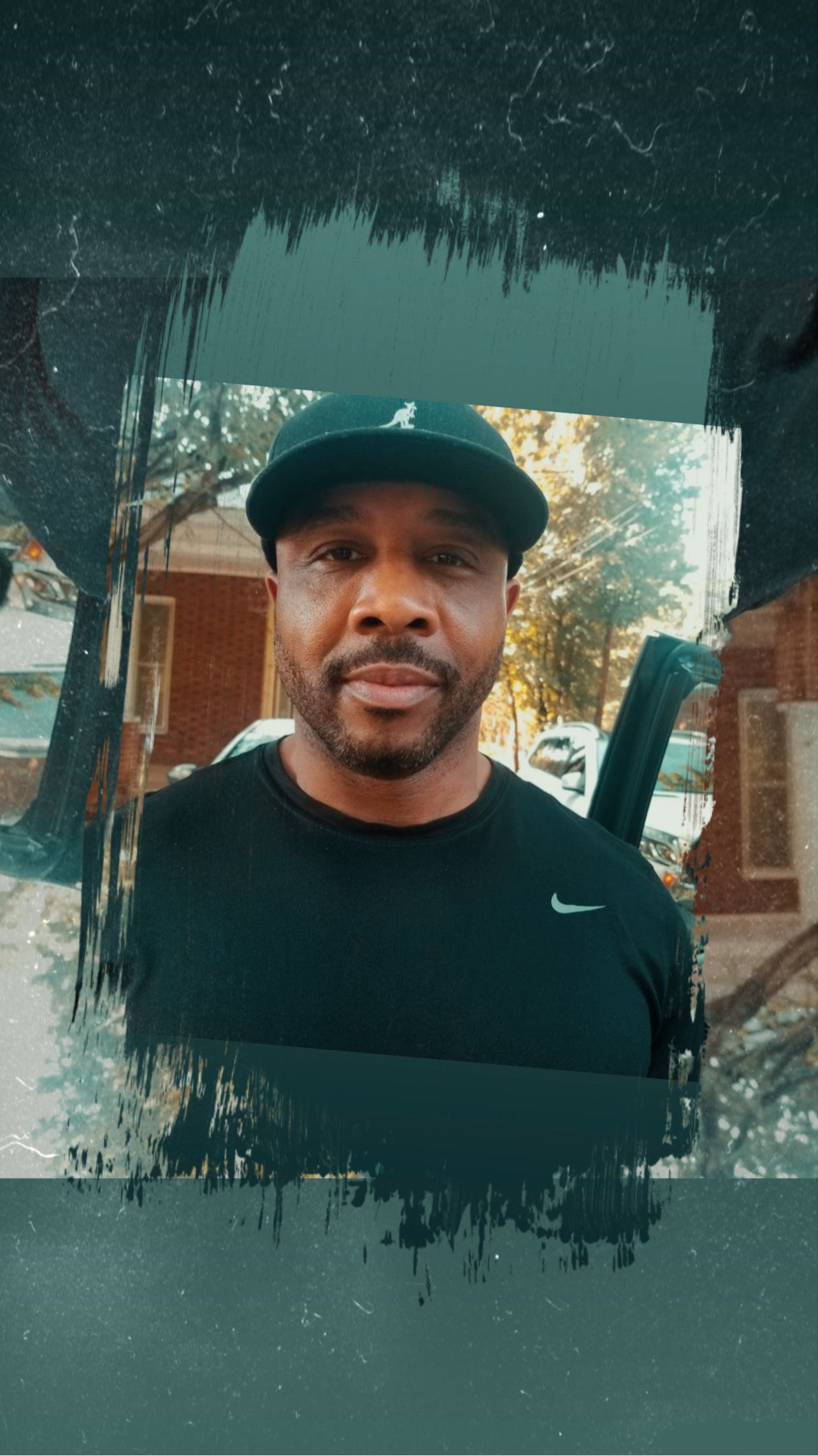 Man in black shirt and cap, outdoors, facing forward.