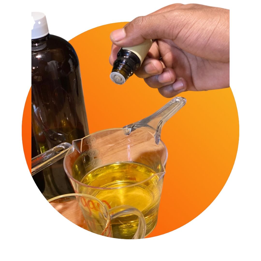 Person adding oil from a roller bottle into a measuring cup with yellow liquid, next to a dark bottle.