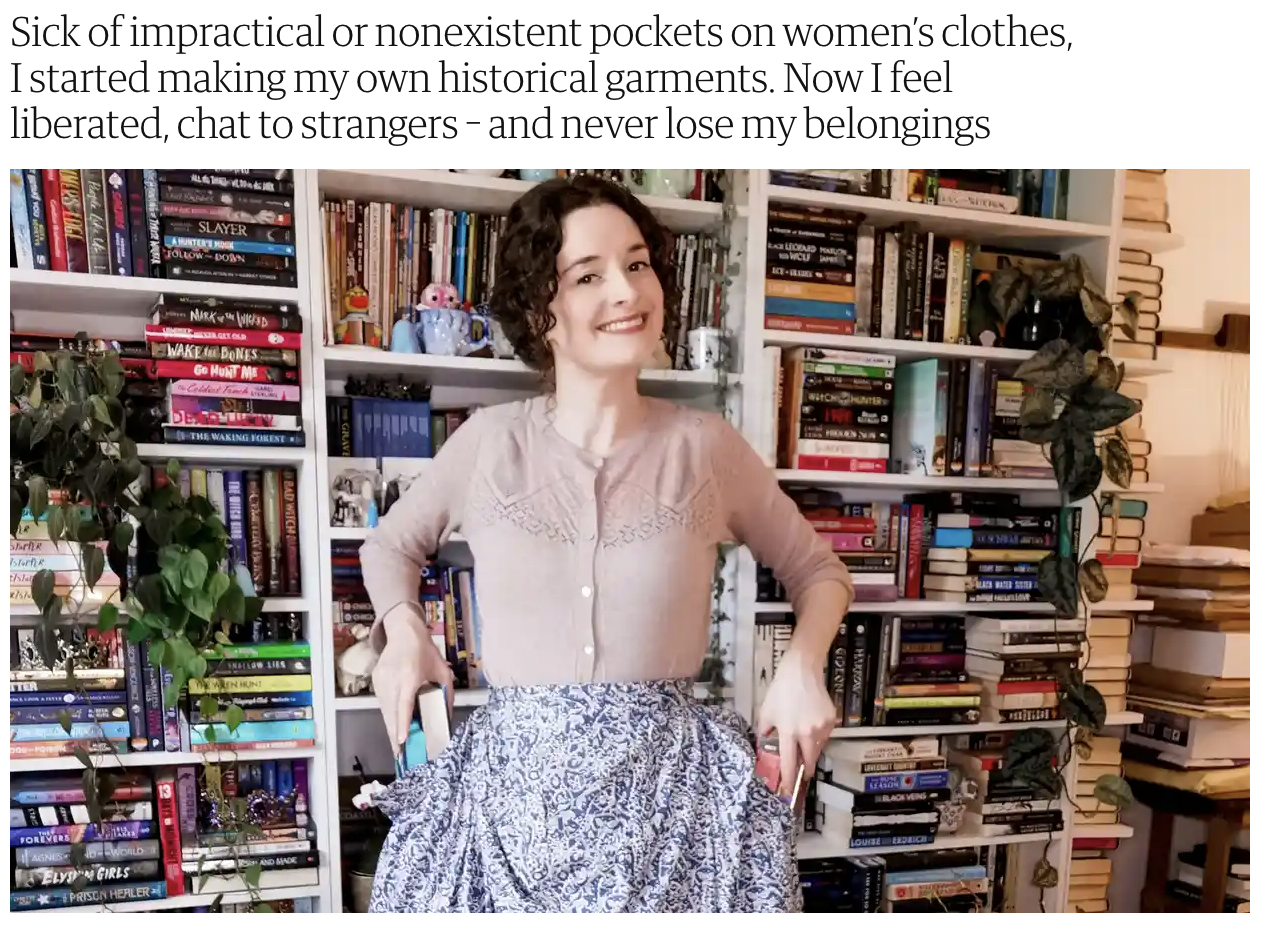 A woman is standing in front of a bookshelf wearing a skirt.