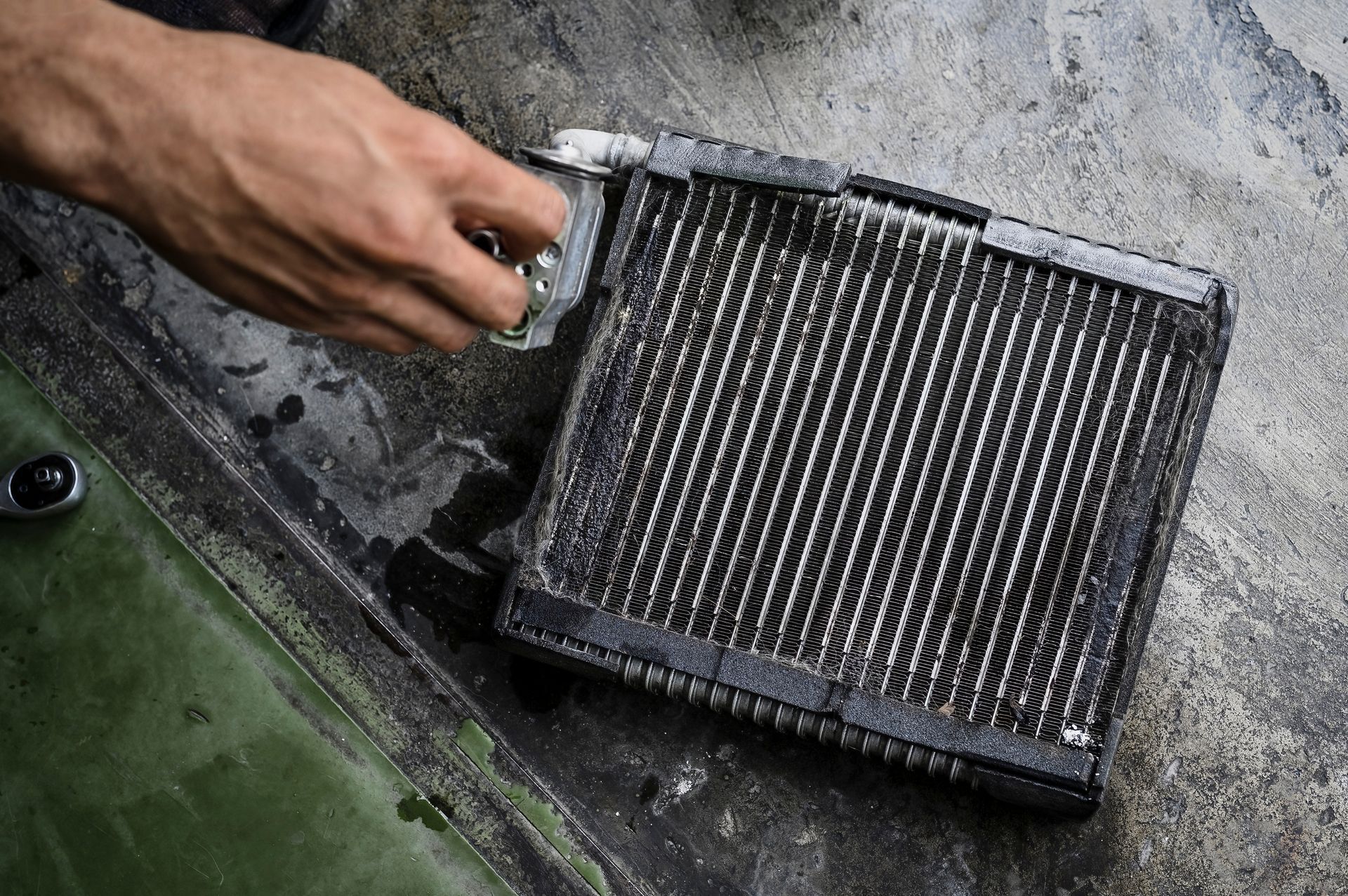 A person is cleaning a radiator with a brush.
