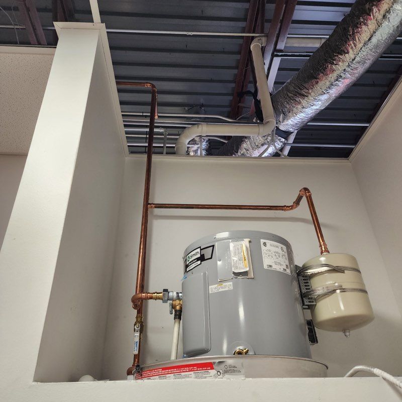 Woman in straw hat smiles, holding wine glass near a lake.