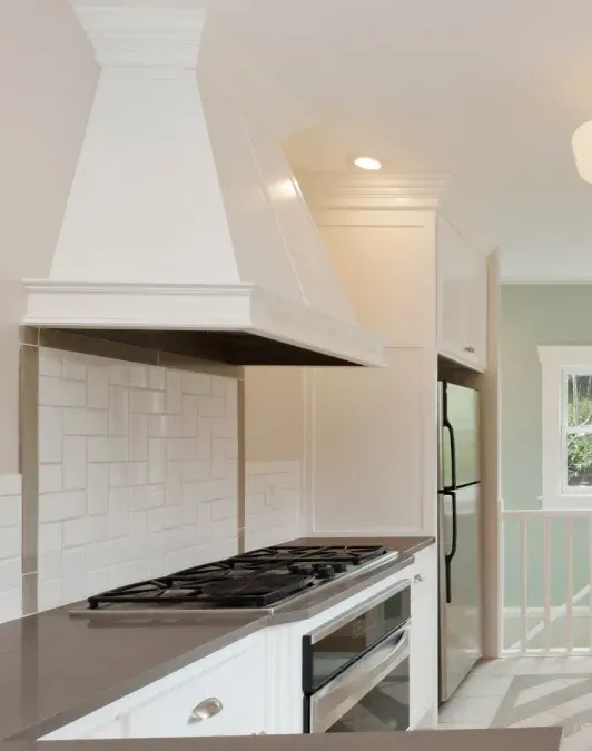 A kitchen with a stove top oven and a refrigerator