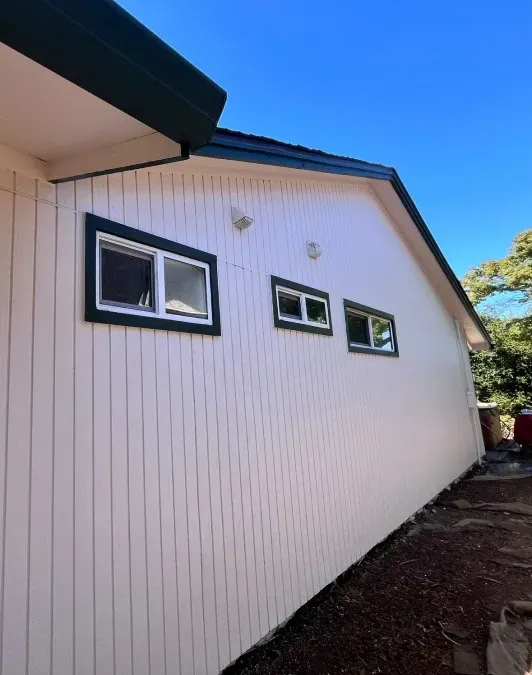A white house with three windows on the side