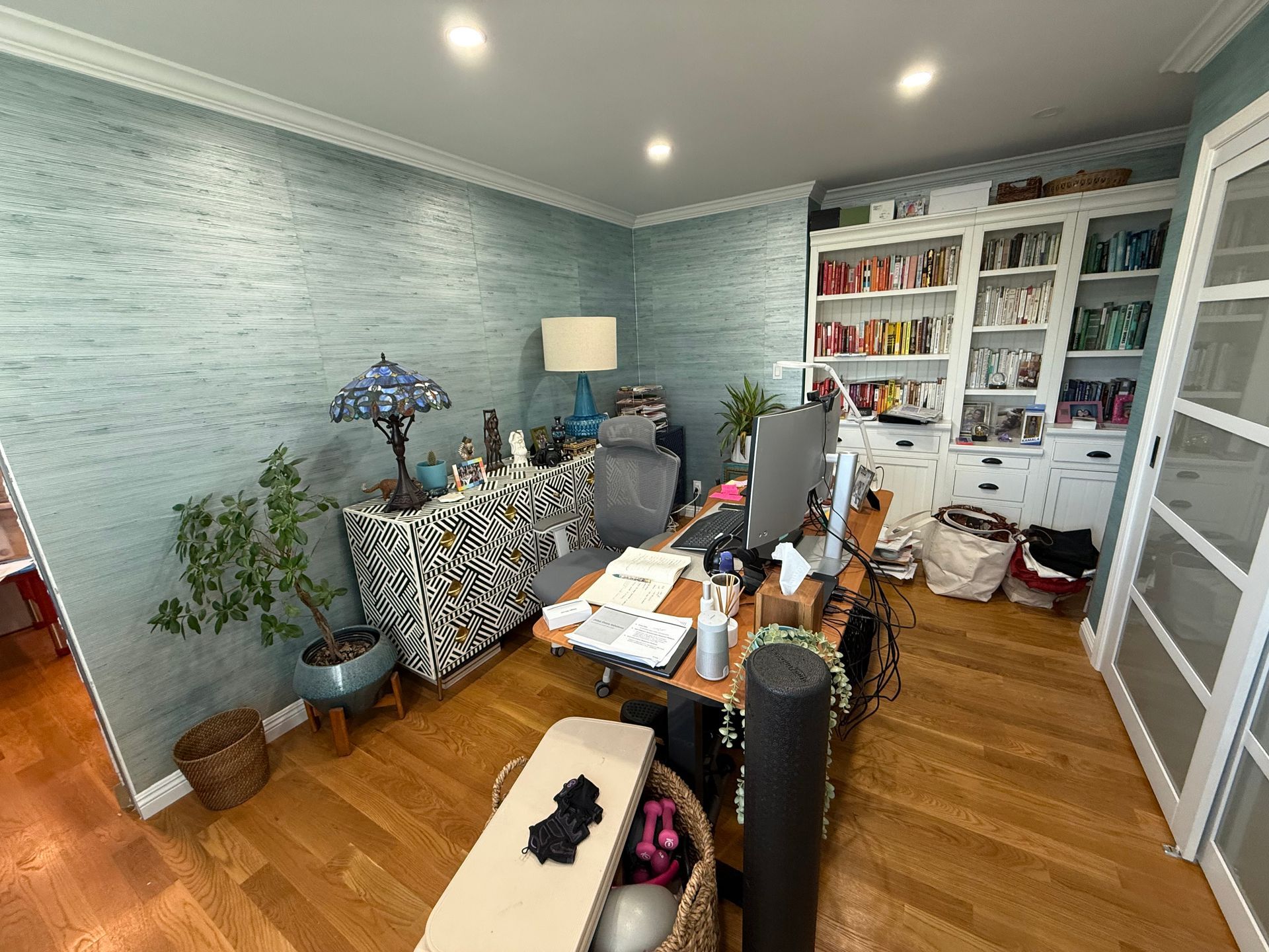 A home office with a desk , chair , lamp and bookshelves.